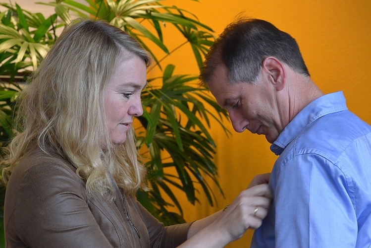 KNMI meteoroloog Marco Nolet krijgt de inhuldigingsmedaille opgespeld door minister Melanie Schultz van IenM 