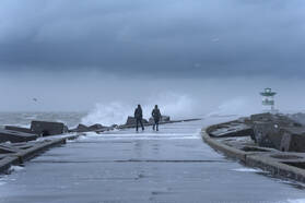 Twee mensen tijdens een storm op een pier