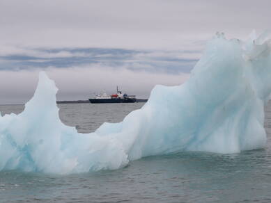 foto van Het SEES-expeditieschip de Ortelius te midden van smeltende ijsbergen