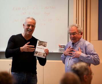 Historisch geograaf en weerhistoricus Jan Buisman (rechts) overhandigt het eerste exemplaar van zijn boek Extreem weer aan Mees Westrate, voorzitter van de Vereniging voor Weerkunde en Klimatologie (Foto: Karin Broekhuijsen) 