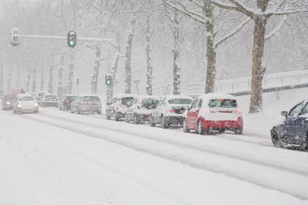 auto's wachten voor een stoplicht in de sneeuw
