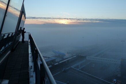 Foto van schiphol en een vliegtuig in de mist