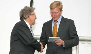 Prof. dr. P. J. Crutzen overhandigt het eerste exemplaar van zijn brochure aan Zijne Koninklijke Hoogheid de Prins van Oranje.