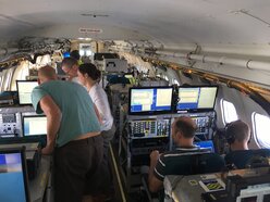 Binnenin de BA-146, en zijn bemanning. Tijdens de vlucht wordt er continu gemeten, en gejaagd op de beste omstandigheden, in dit geval rook in combinatie met wolken