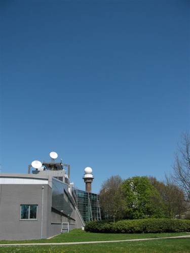 Figuur 1. Zaterdag 17 april 2010: het KNMI onder een strakblauwe hemel zonder enig spoor van vliegtuigactiviteit. Foto: Wouter Knap, KNMI.