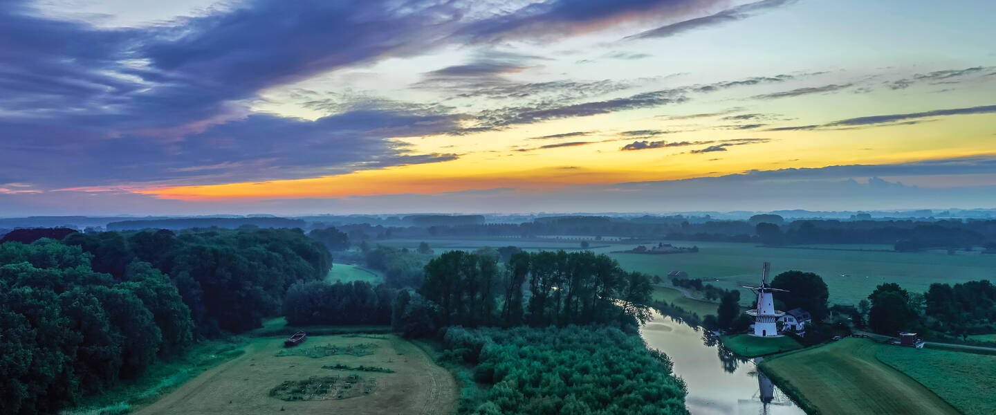 Luchtfoto van een typisch Nederlands landschap met molen