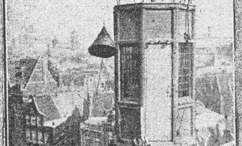foto van de toren van het gebouw Neptunus aan de Nieuwe Zijds Voorburgwal in Amsterdam, waarop "geregeld bij dag en nacht seinen worden geheschen, die de verwachting betreffende storm aangeven". De foto is gemaakt tijdens "het hijschen van een signaal"