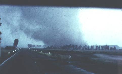 Windhoos van 25 juni 1967 enkele seconden voordat bij het verkeersplein een loods verwoest wordt en vervolgens een aantal auto's op het middenterrein wordt geworpen. Let op het effect van de wind op de boomgroepen