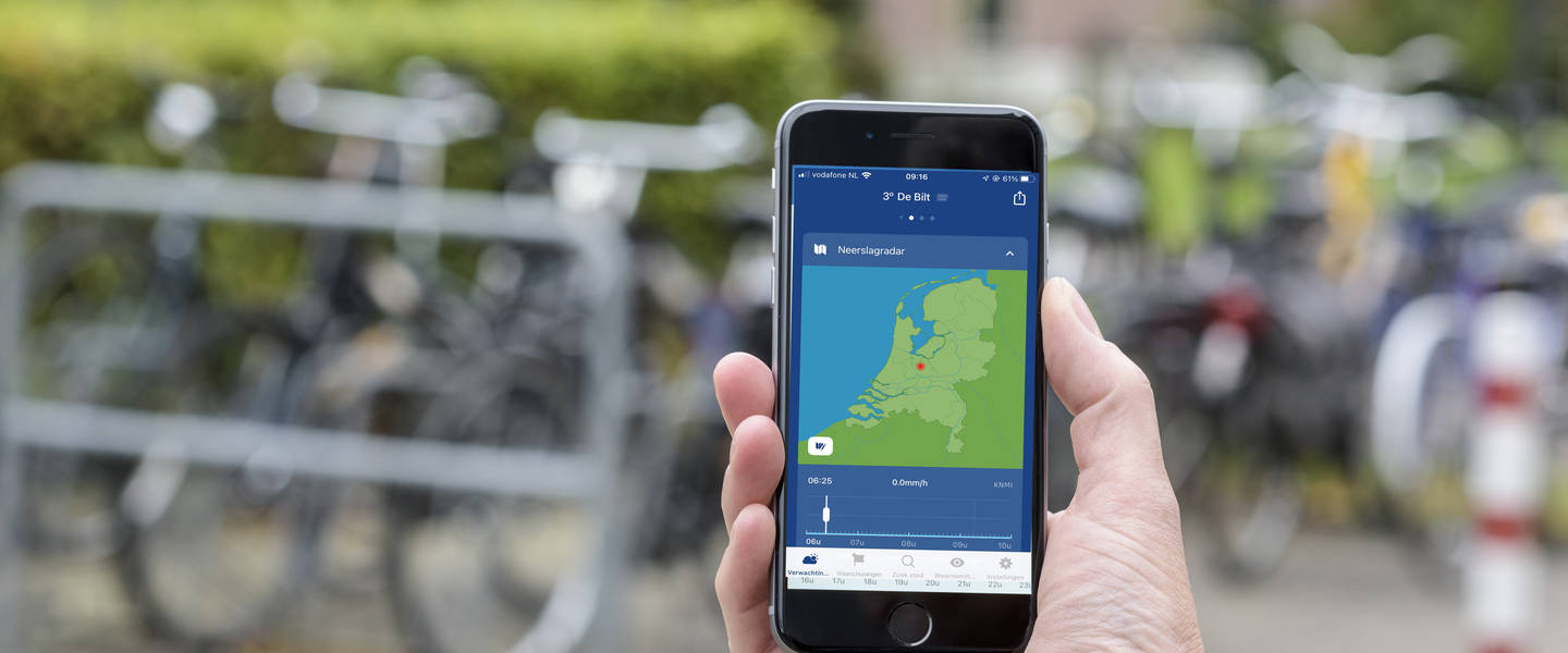 fietser toont knmi weer app op smartphone
