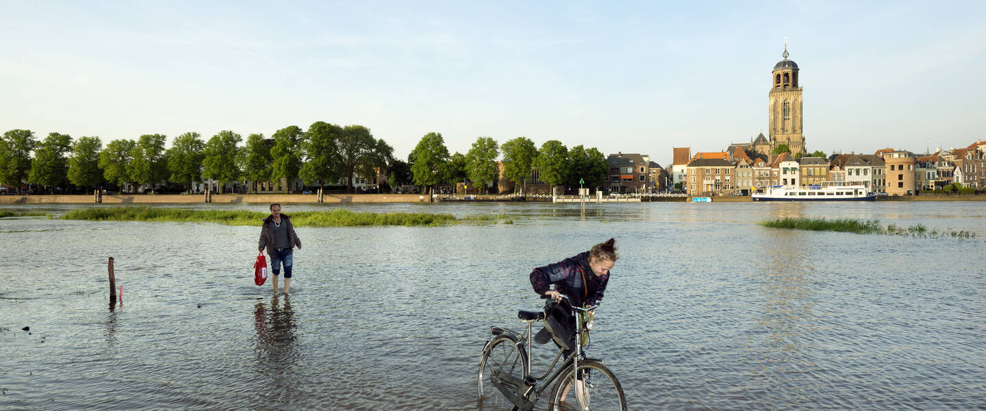 fietser loopt door hoogwater in deventer