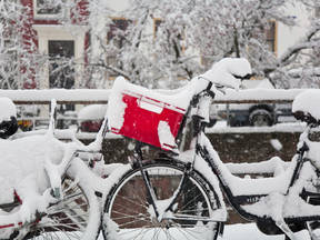 Fiets met rode fietstas in de witte sneeuw