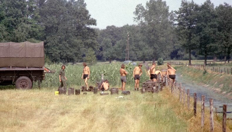 Soldaten bij een truck in een verdroogd weiland