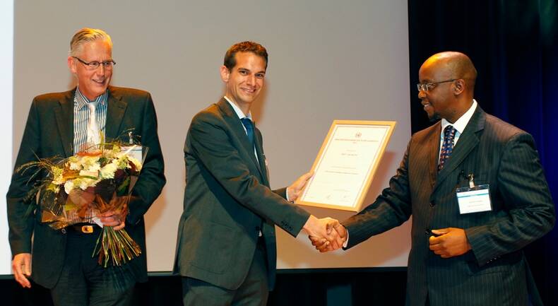Plaatsvervangend secretaris-generaal van de WMO Jeremiah Lengoasa reikt de Young Scientist Award uit aan Ruud van der Ent. (Foto: Roy Borghouts Fotografie)