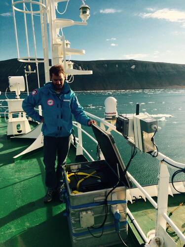 Oliver Andry van het KNMI bij de MAXDOAS op het schip de Ortelius omringd door zeeijs op Spitsbergen. foto KNMI 