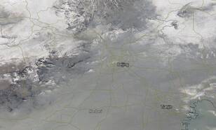 Het satellietbeeld van MODIS op 7 december 2015 laat noordoost China zien onder een deken van smog dat zich uitstrekt tot de bergen in het noordwesten. (Bron: NASA)