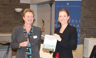 Initiator Anita Buma (RUG) overhandigt het eerste exemplaar van "Door de kou bevangen" aan Stientje van Veldhoven Tweede Kamerlid voor D66 en deelnemer aan de meest recente poolexpeditie SEES.NL. Foto: Klaas van Manen 