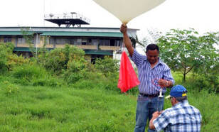 twee mensen laten een weerballon op in paramaribo