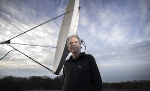 Geert Jan van Oldenborgh poseert voor een satelliet