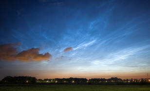 Foto uit 2021 van lichtende nachtwolken die bijna tot aan het zenit zichtbaar zijn.