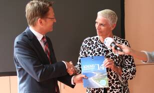 Staatssecretaris Wilma Mansveld neemt het rapport met de KNMI'14-klimaatscenario's in ontvangst uit handen van KNMI-hoofddirecteur Gerard van der Steenhoven (foto: Patricia van der Kooij, KNMI)