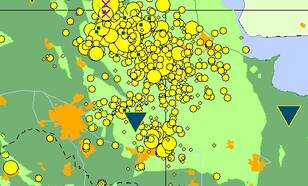 Aardbevingen in het Groningen gasveld van 1990 tot heden worden weergegeven met gele cirkels. De bevingen van 7 en 8 februari worden aangegeven met paarse kruisjes. In lichtgroen het gasveld, in blauwe driehoeken en vierkanten seismische meetstations.