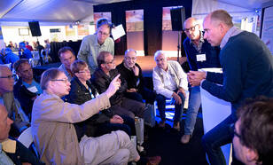 Aan thematafels konden vragen aan wetenschappers gesteld worden over weer, klimaat en seismologie. foto KNMI / Jeanette Schols