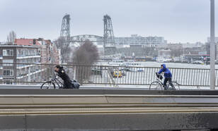 fietsers met storm op de erasmusbrug in rotterdma