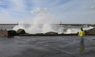 jongen kijkt naar de storm aan de nederlandse kust