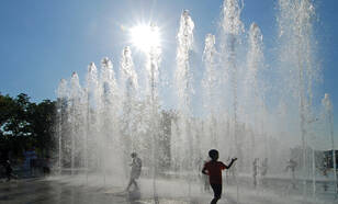 Kinderen zoeken verkoeling bij fontein 