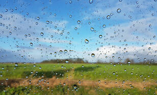 regendruppels voor blauwe lucht en groen weiland