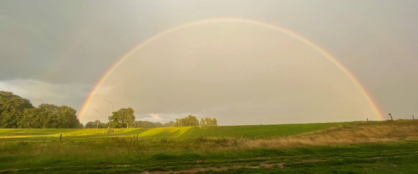 Foto van een dubbele regenboog en bui. 