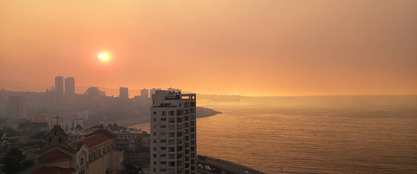 Rook bij zonsondergang boven de stad Viña del Mar in Chili