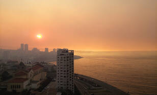 Rook bij zonsondergang boven de stad Viña del Mar in Chili