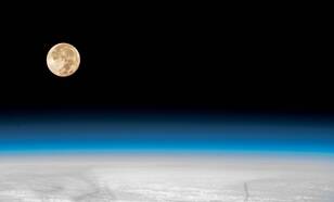 De maan en de aarde gezien vanuit het International Space Station