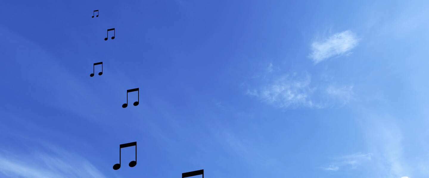 Foto van blauwe lucht met vallende muzieknoten