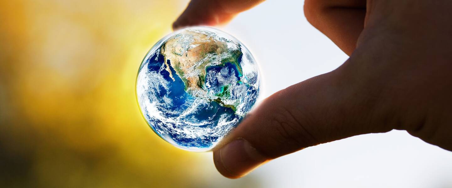 Miniature earth between thumb and index finger