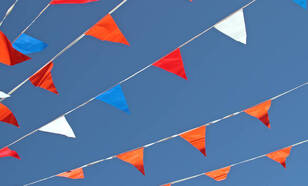 Rood-wit-blauwe en oranje vlaggetjes in een blauwe lucht