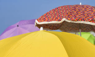 drie parasollen op een zonnig strand