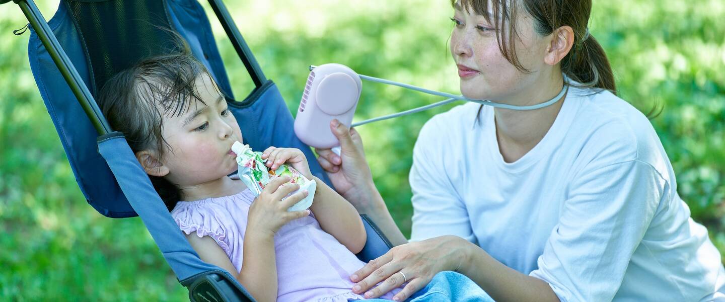 Moeder en kind in de schaduw om af te koelen