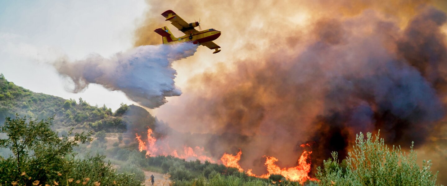 Blusvliegtuig boven brandend landschap