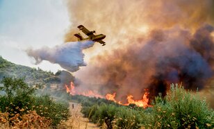 Blusvliegtuig boven brandend landschap